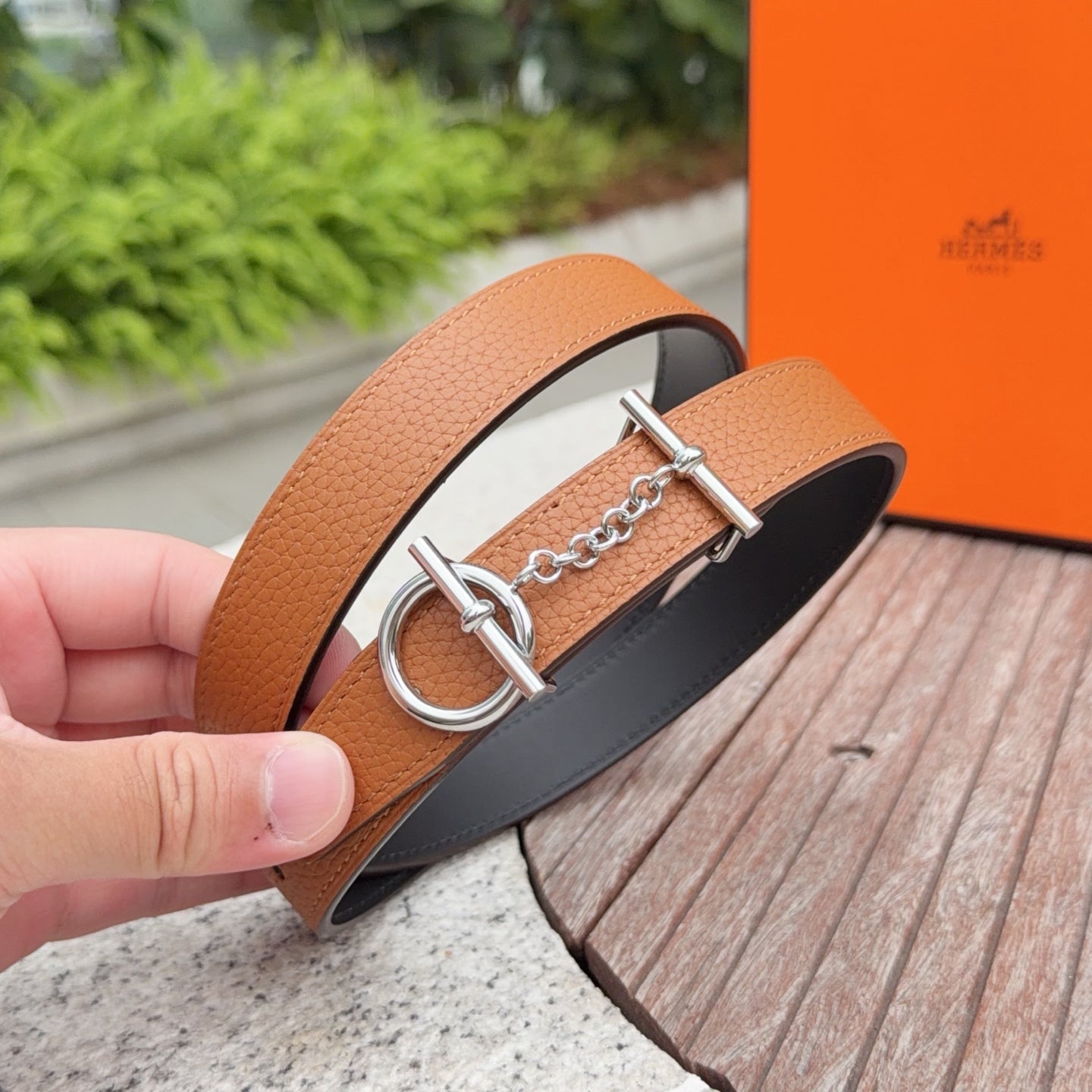 Hermes leather belt close-up with tan strap and silver double-ring buckle