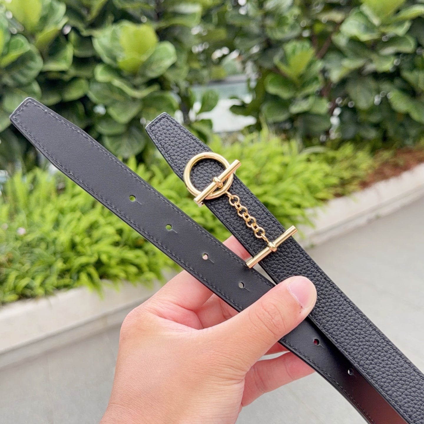 Gray leather belt with gold-tone buckle and chain; visible belt holes