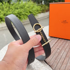 Charcoal leather belt with gold buckle and chain; handheld close-up