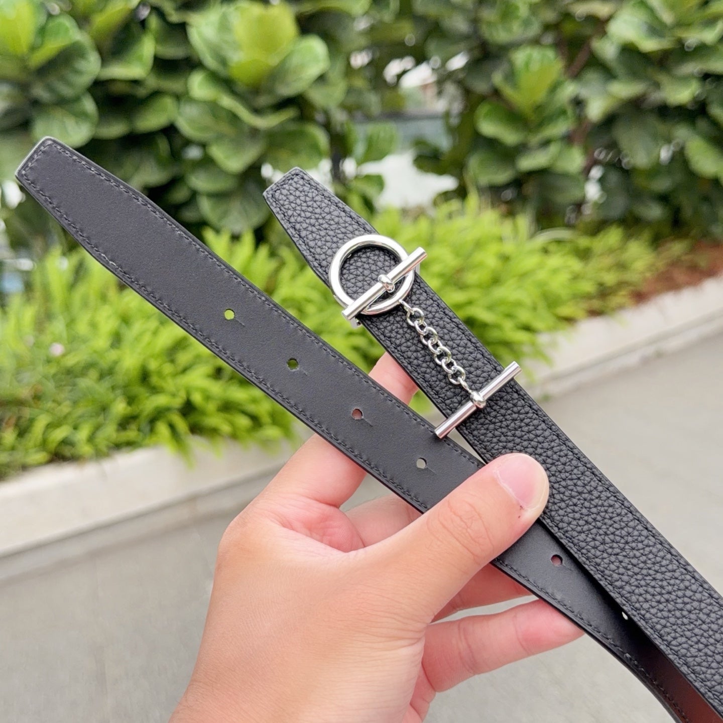 Hermes belt underside with dark leather, rows of holes, and silver-tone buckle ring