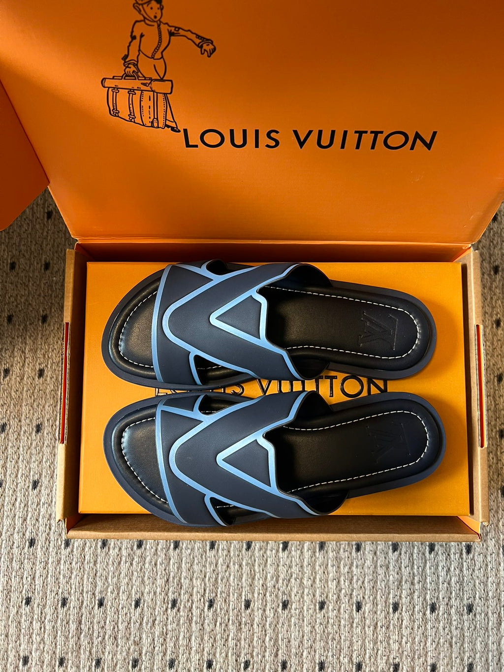 Louis Vuitton slide sandals, black with light blue V logo, pair top view