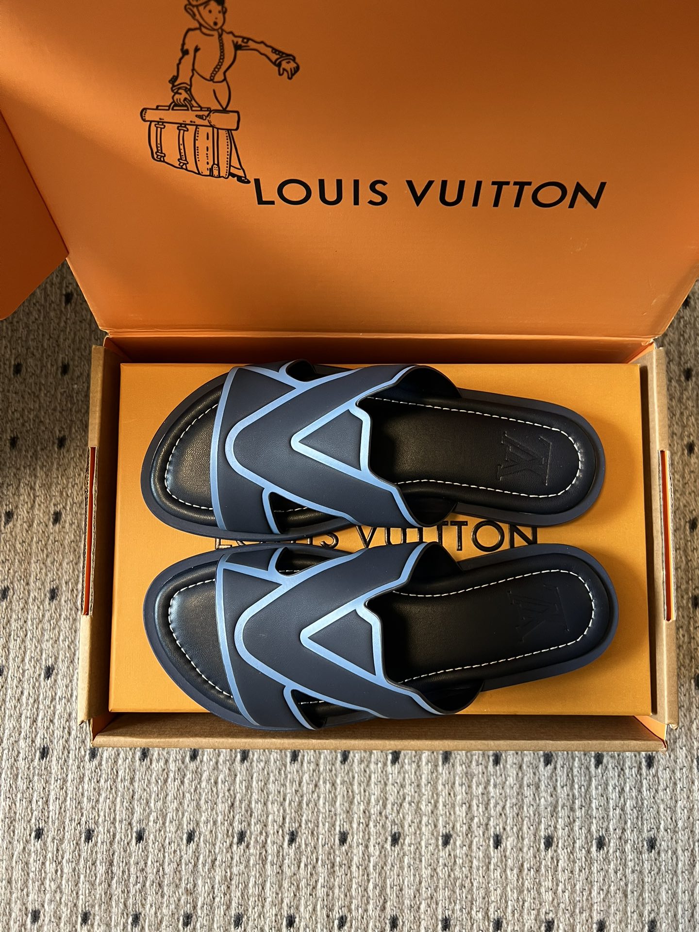 Louis Vuitton slide sandals, black with light blue V logo, pair top view