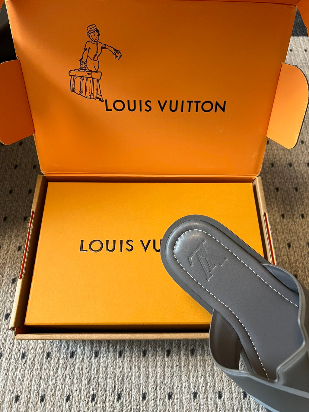 Louis Vuitton slide sandal, dark gray with contrast straps, partially shown in box
