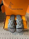 Louis Vuitton slide sandals in dark gray, shown in open orange shoe box