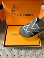 Louis Vuitton slide sandal close-up, dark gray upper with white V-shaped trim