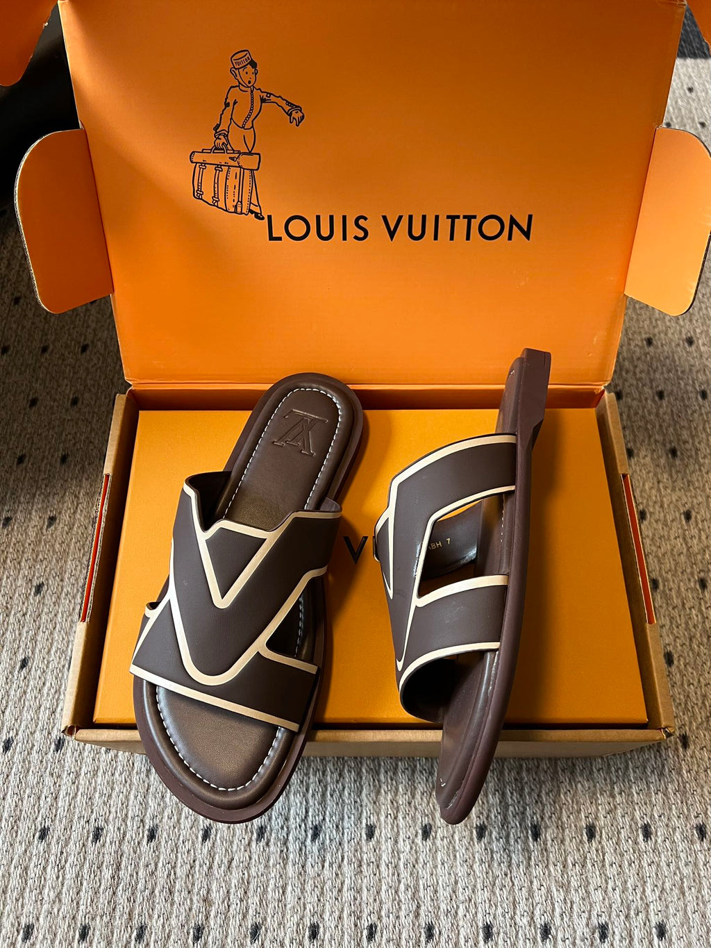 Dark slide sandals with white V-shaped strap detail