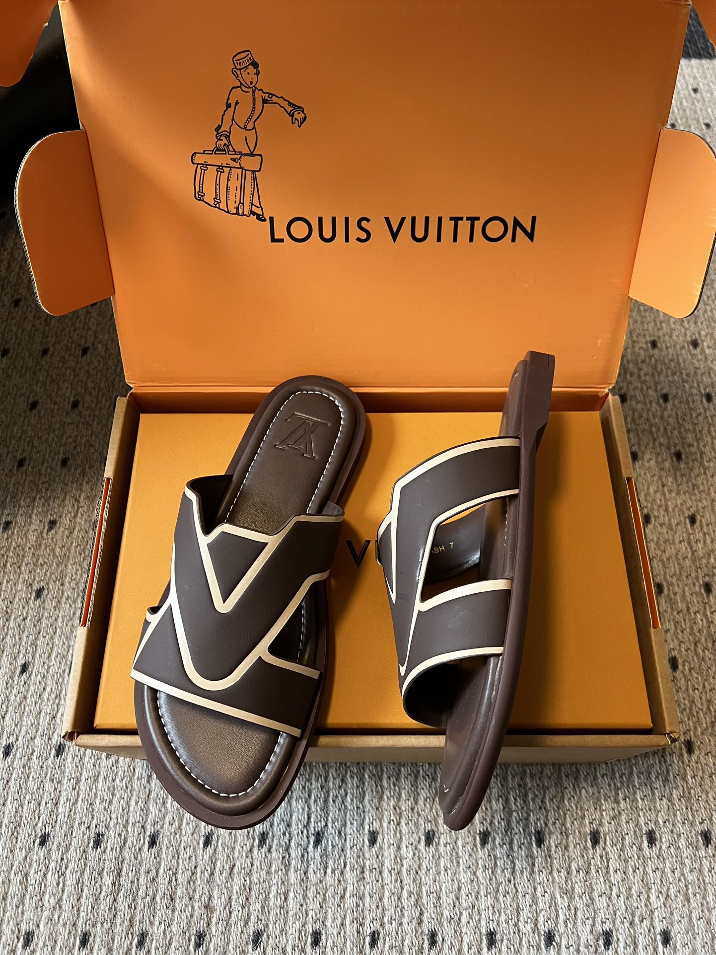 Dark slide sandals with white V-shaped strap detail