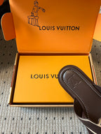 Dark slide sandal with embossed V logo on strap, in shoe box