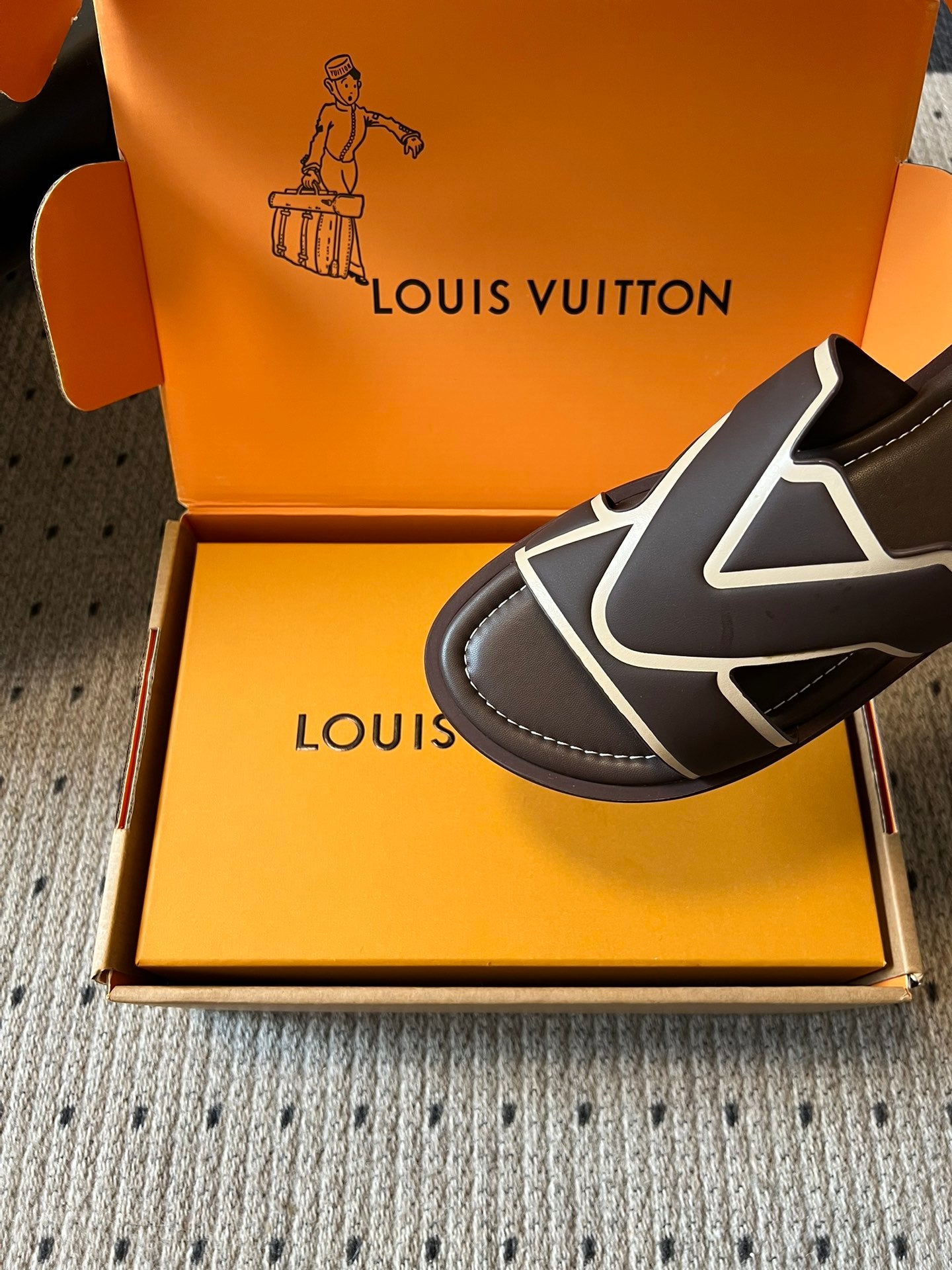 Close-up dark slide sandal with white V strap and stitched sole