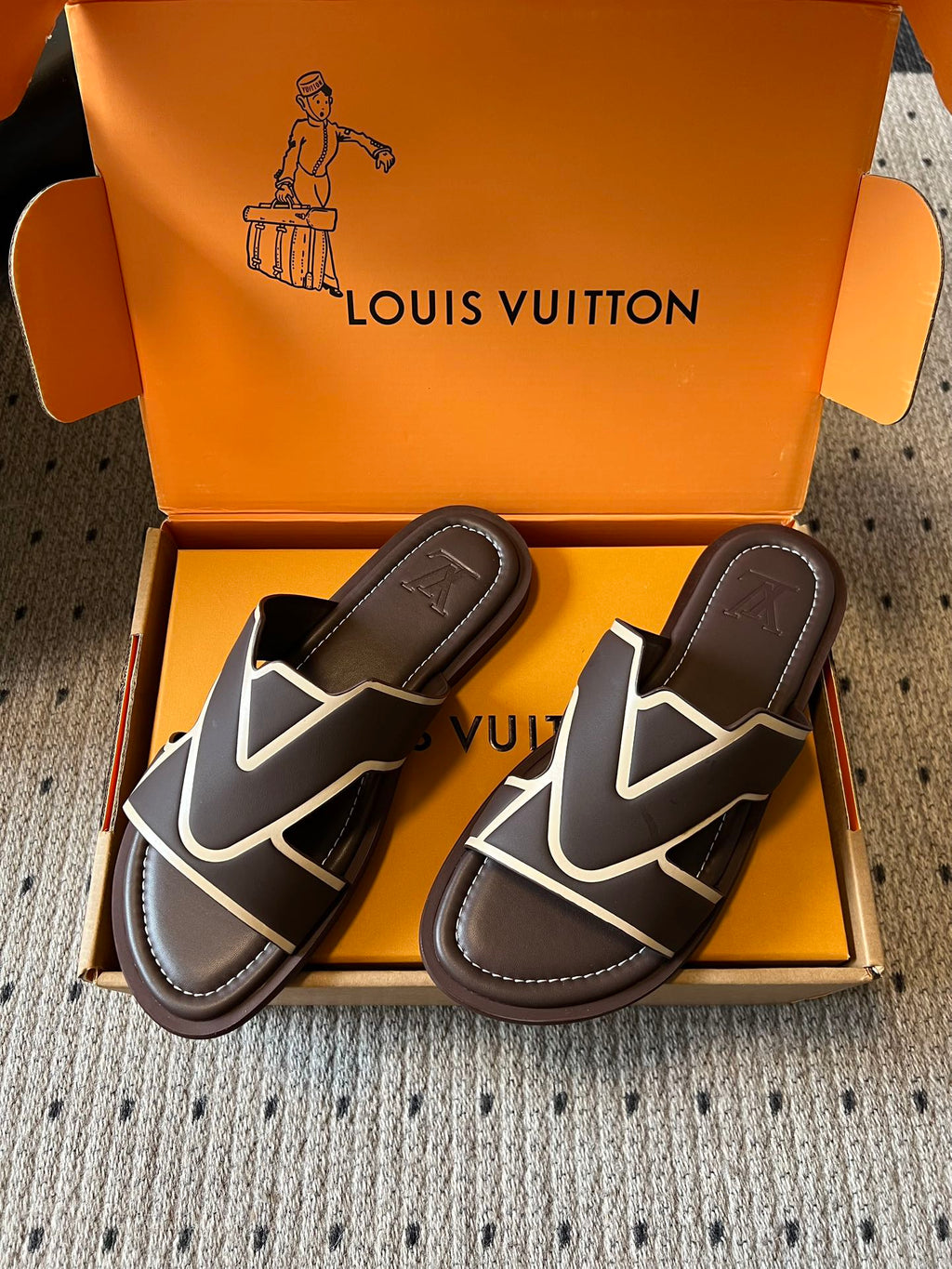 Pair of dark slide sandals with white V motif straps