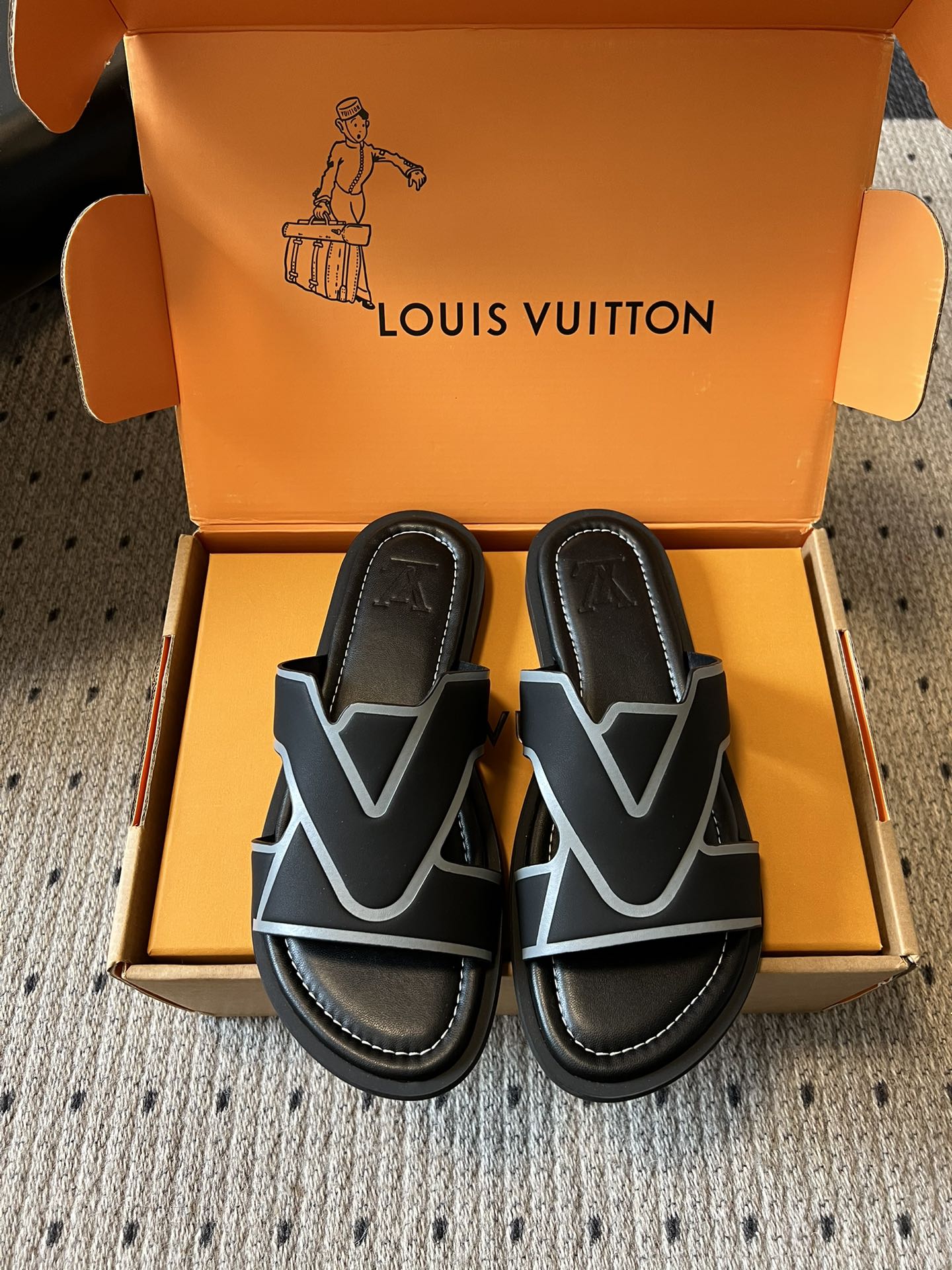 Louis Vuitton sandals in open box, black straps with light blue V detail and cushioned soles