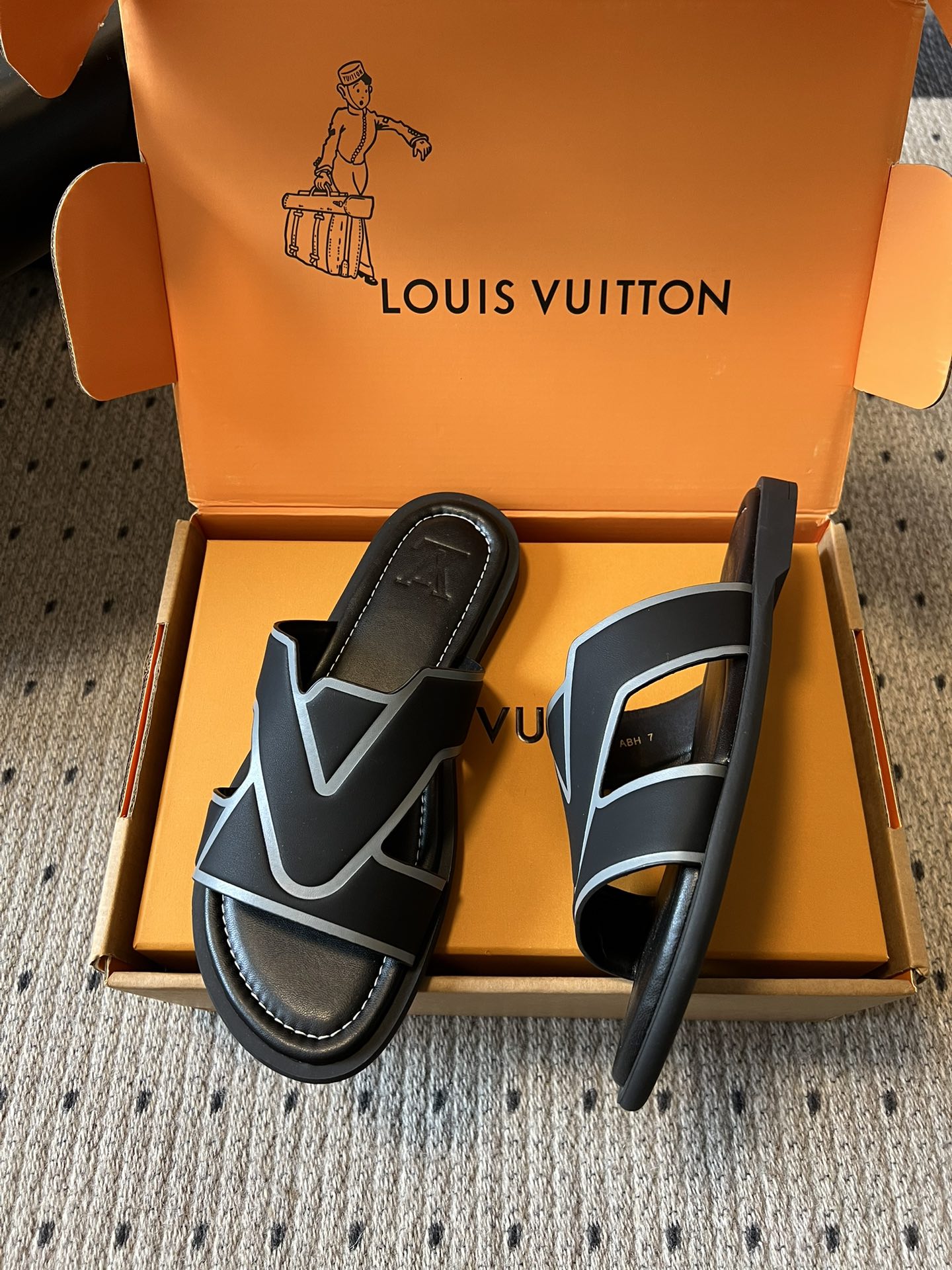 Louis Vuitton sandals with black slide strap and light blue V logo, shown in product box