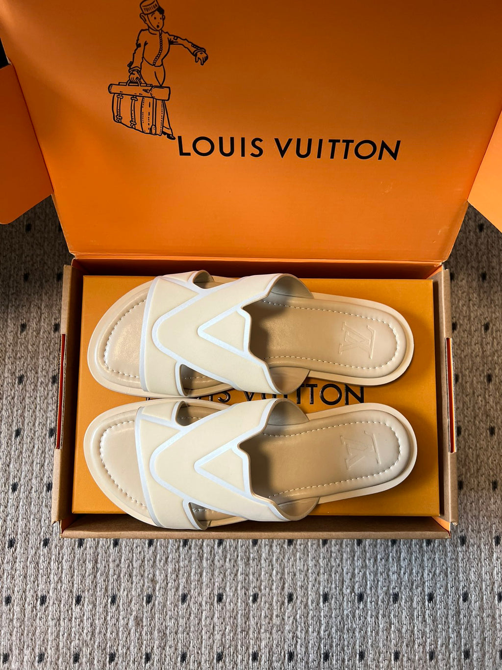 Cream slide sandals showing tan outsole and V strap, in box, Louis Vuitton