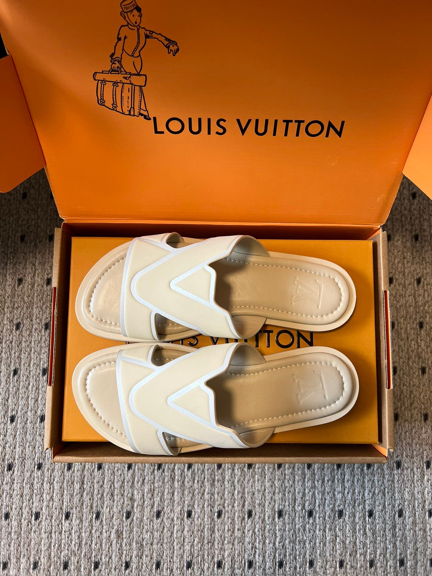 Cream slide sandals showing tan outsole and V strap, in box, Louis Vuitton