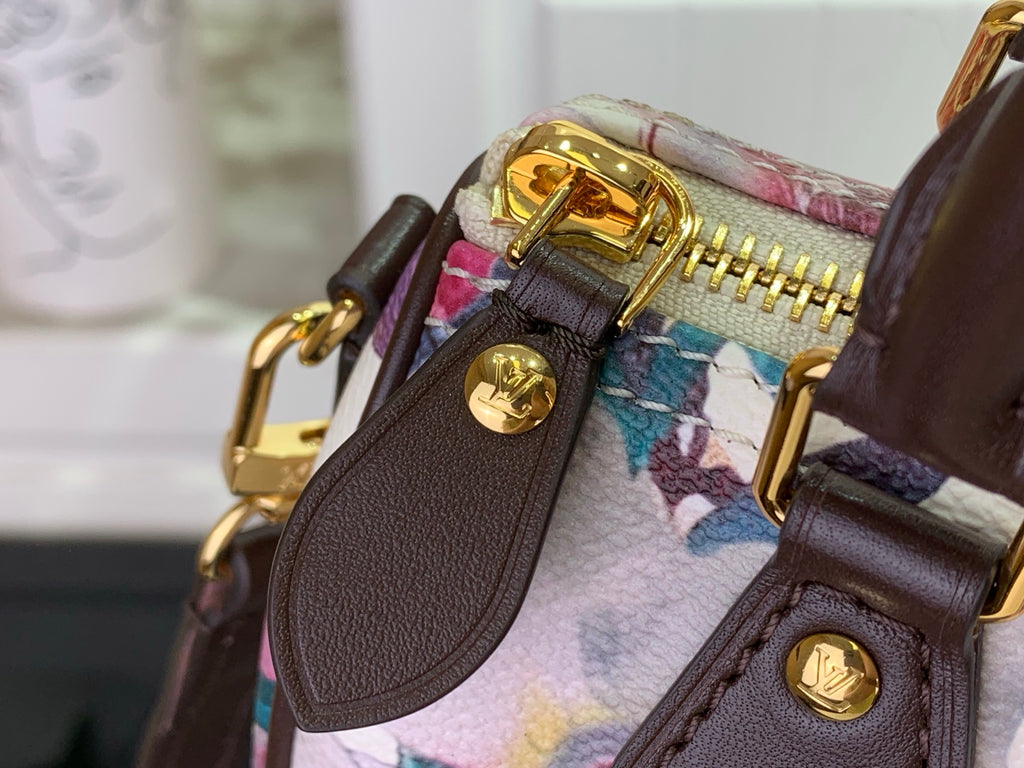 Gold zipper and snap button details on floral fabric with brown leather trim