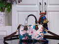 Floral print handbag with dark brown leather handles and shoulder strap