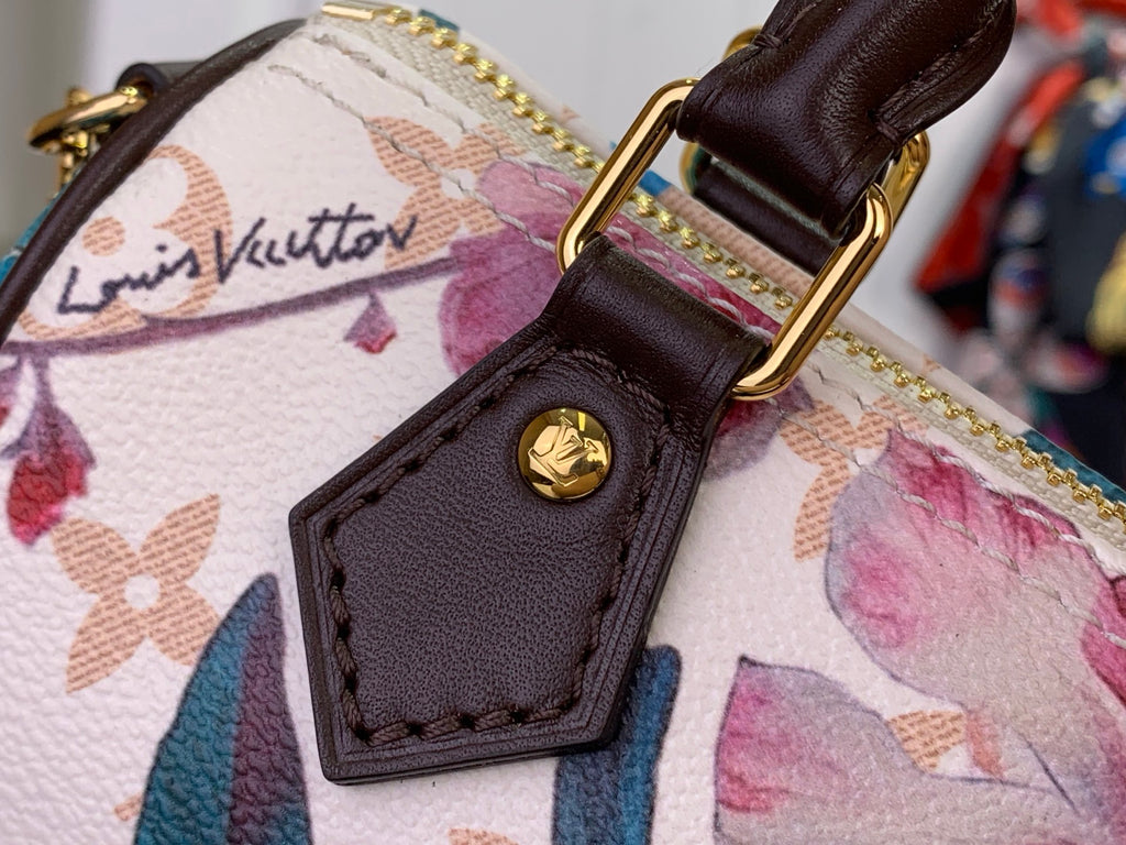 Brown leather logo patch with stitching on floral fabric handbag