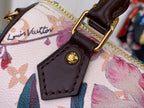 Brown leather logo patch with stitching on floral fabric handbag