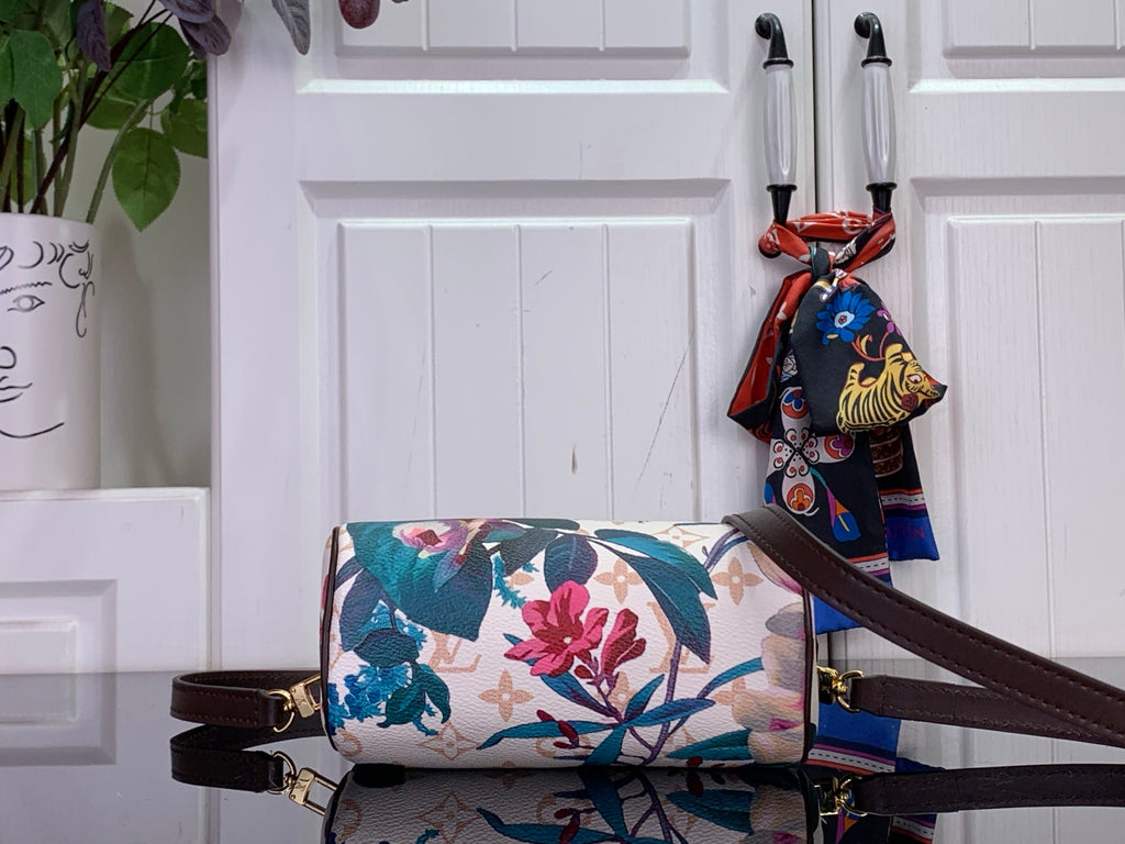 Floral print handbag with dark brown shoulder strap and decorative scarf