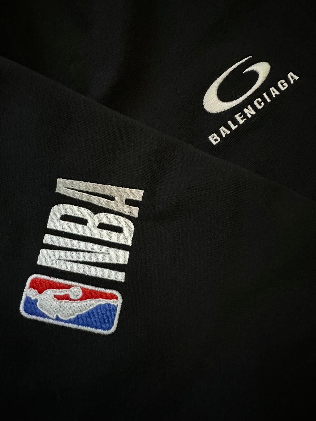 Black shorts close-up of NBA logo patch and Balenciaga logo patch.