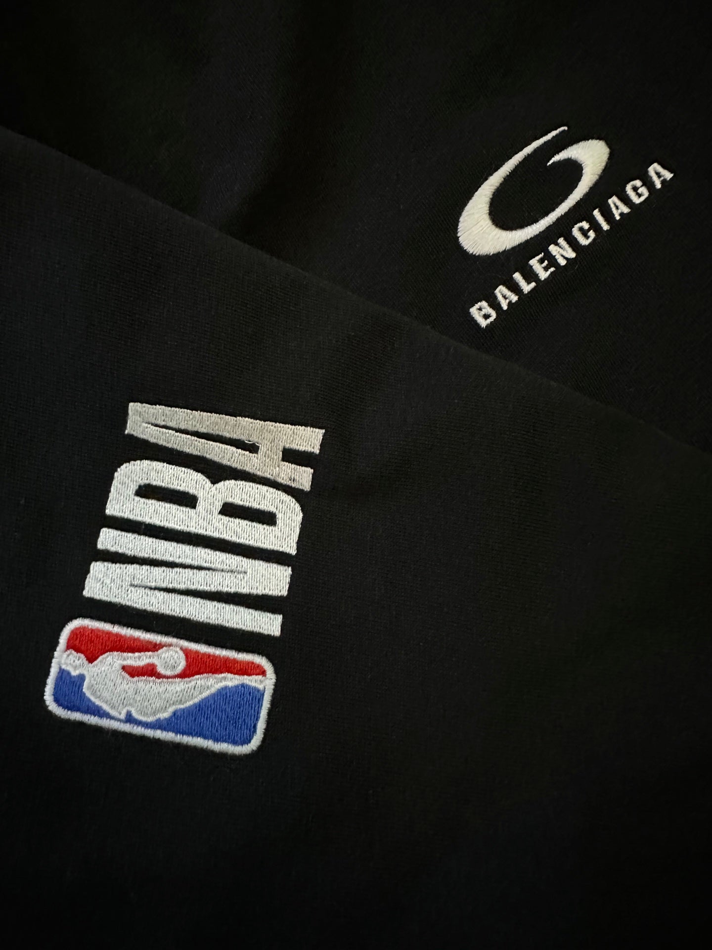 Black shorts close-up of NBA logo patch and Balenciaga logo patch.