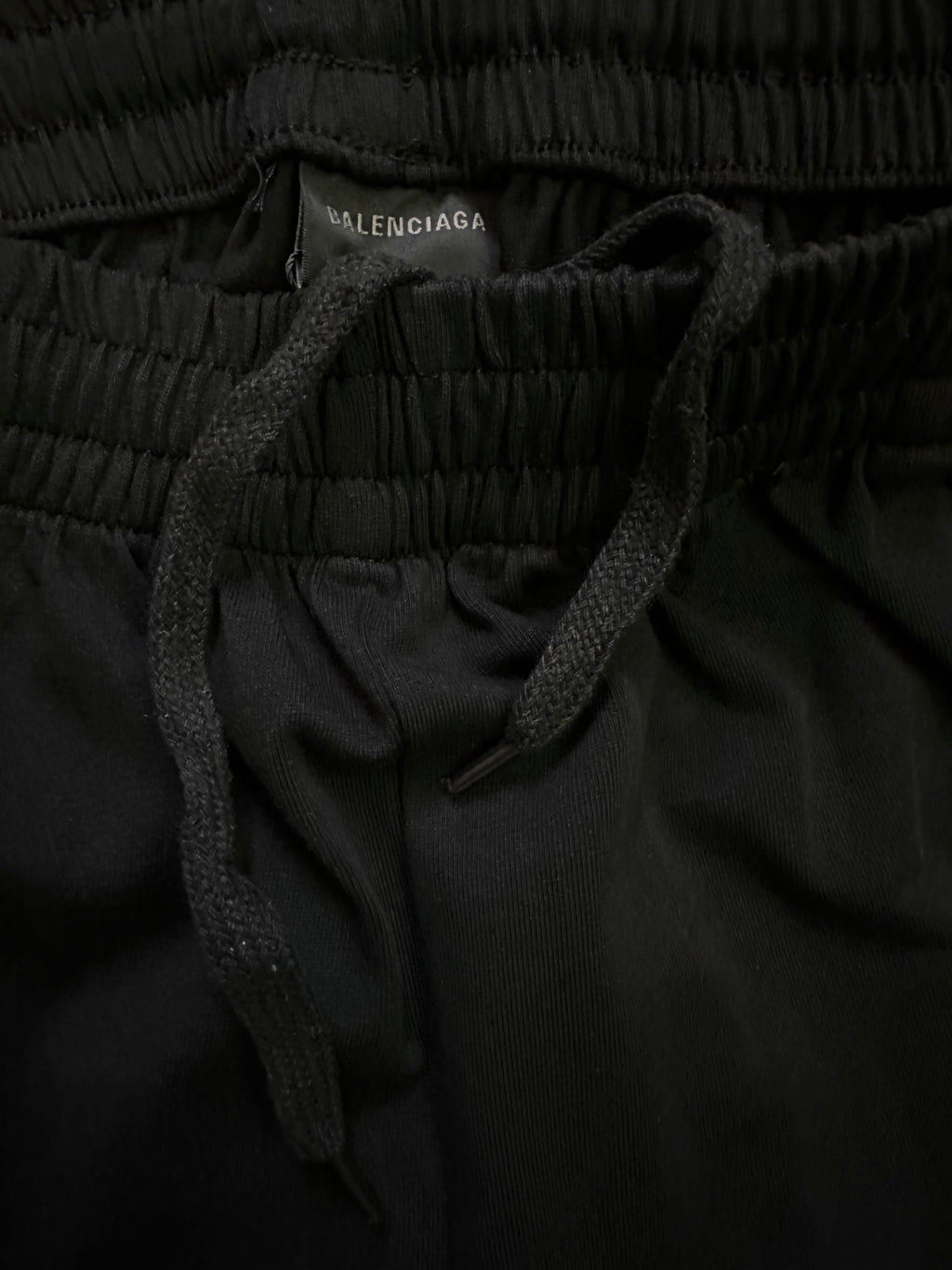 Black shorts close-up showing elastic waistband and dark drawstring.