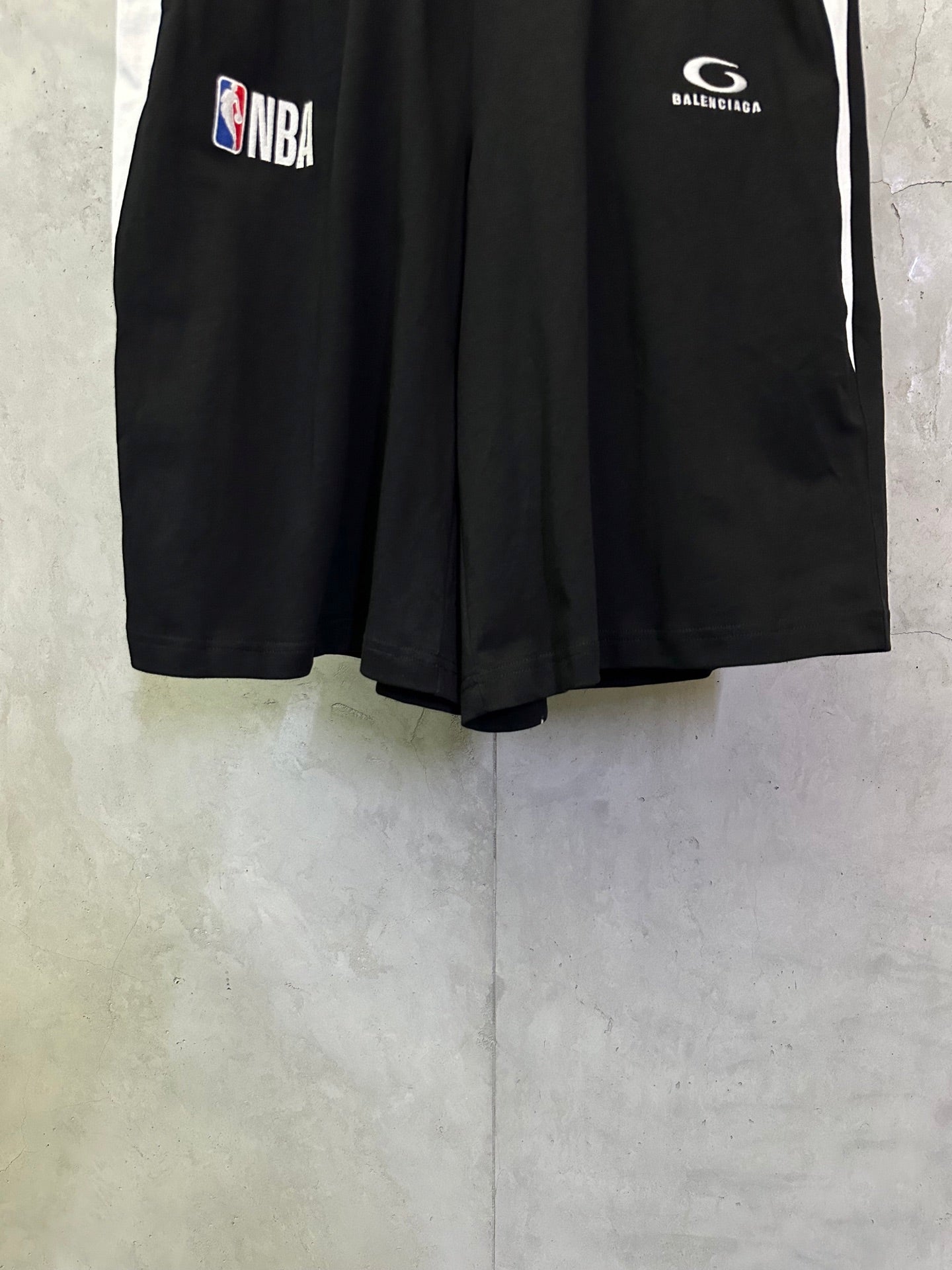 Black shorts with NBA and Balenciaga logo prints on the front.