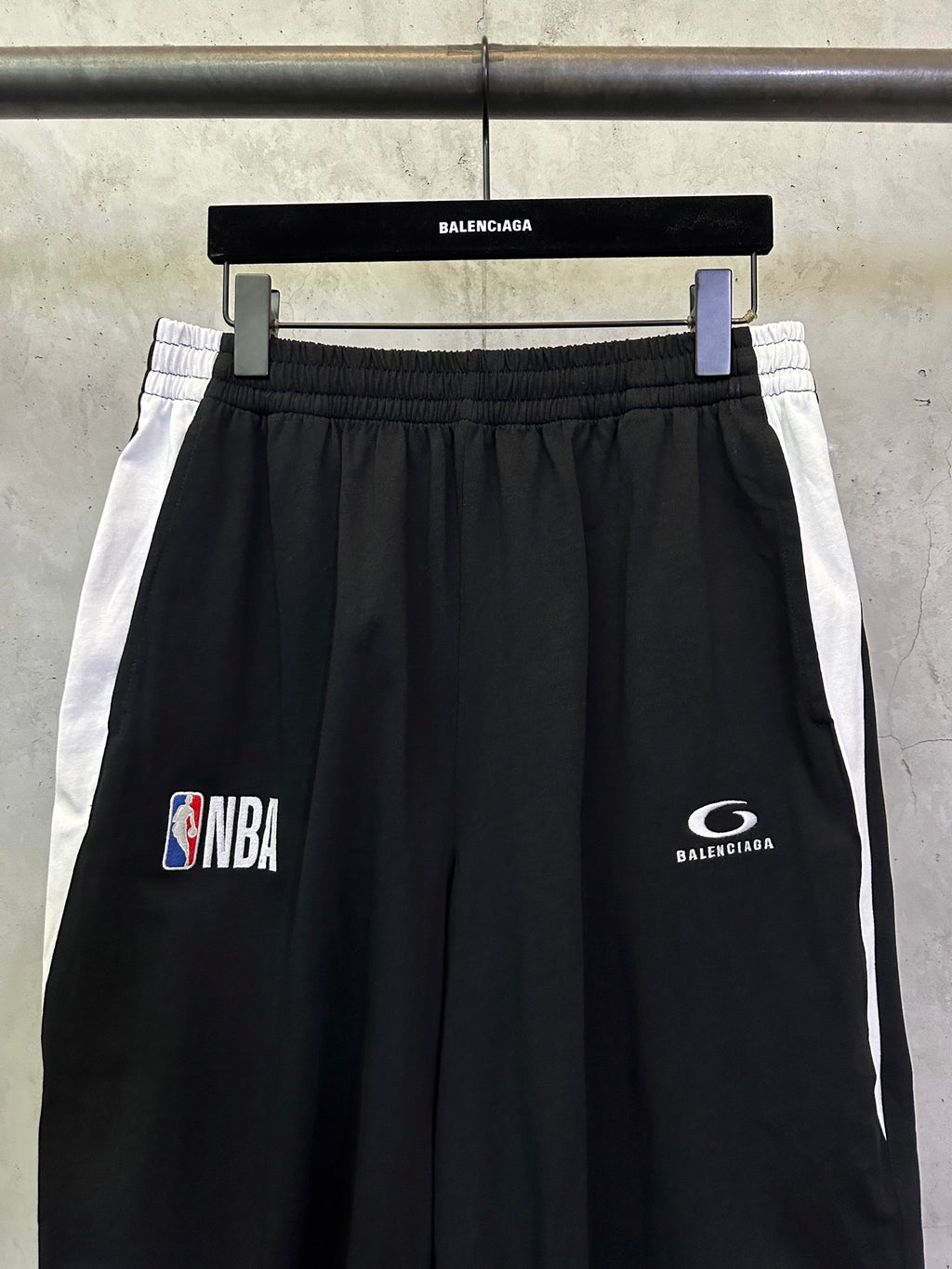 Black shorts with white side stripes, NBA and Balenciaga logo prints.