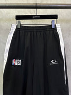 Black shorts with white side stripes, NBA and Balenciaga logo prints.