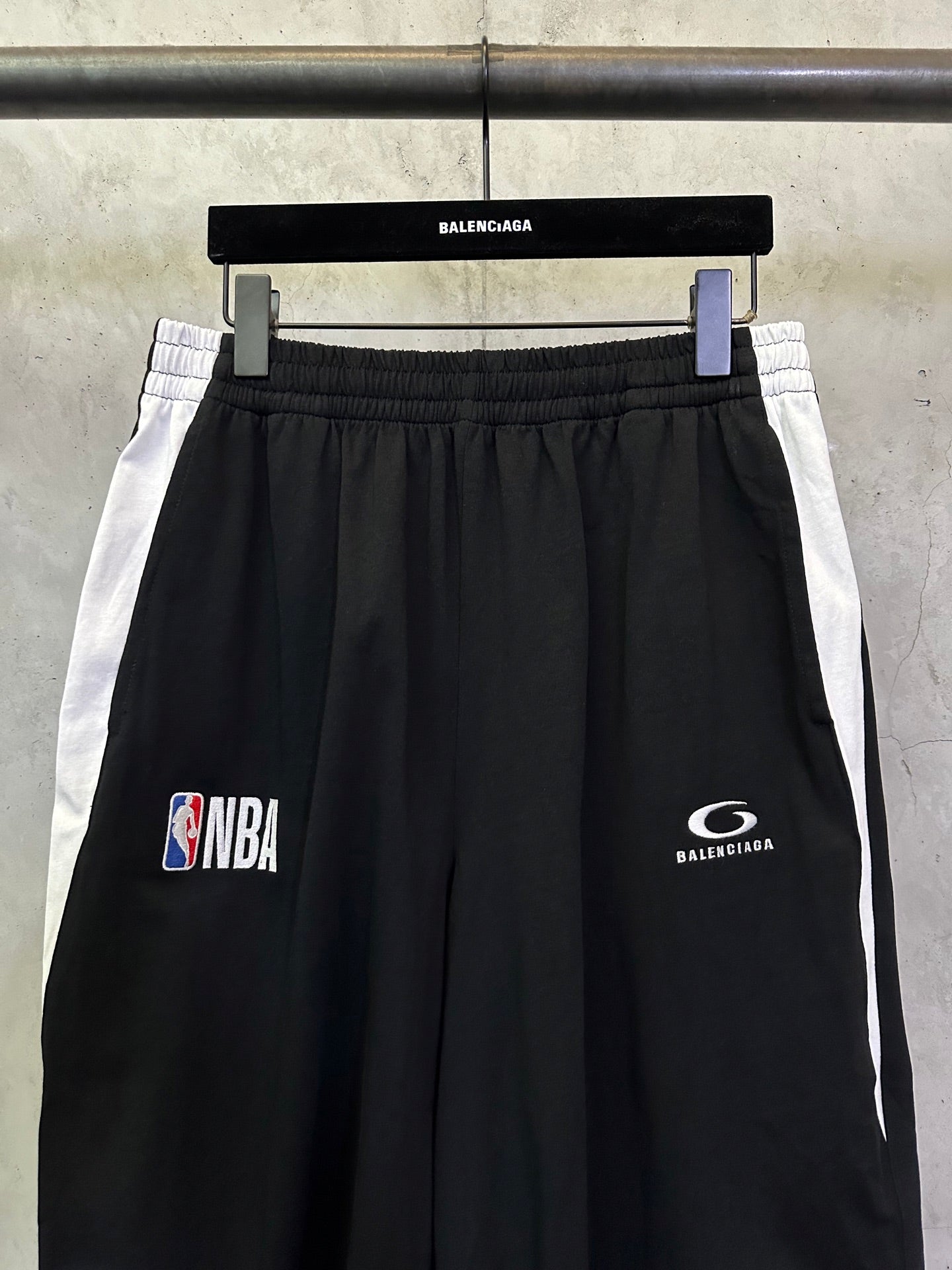 Black shorts with white side stripes, NBA and Balenciaga logo prints.