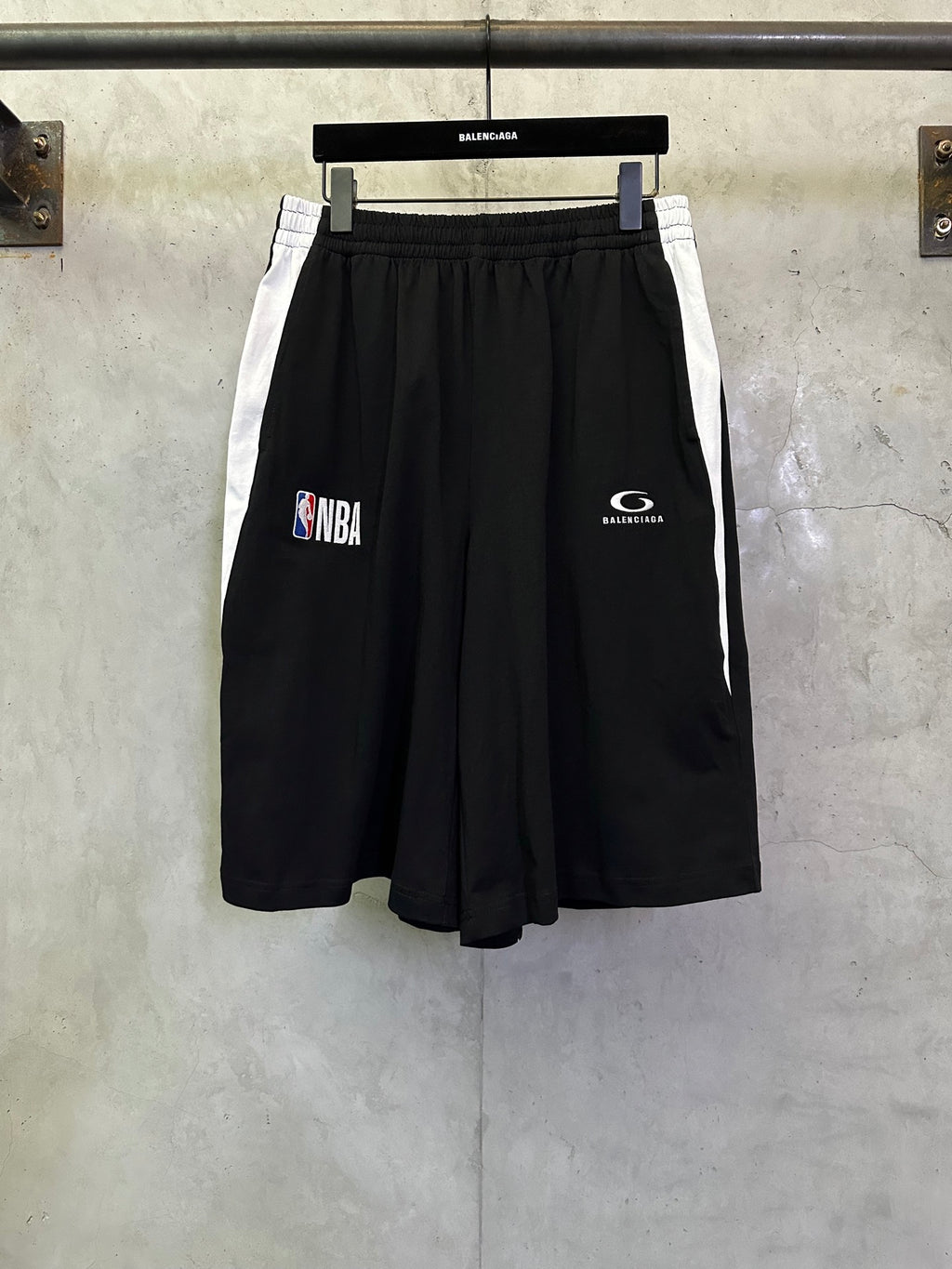 Black shorts with elastic waistband and NBA graphic print on the left leg.