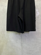 Black shorts back view with draped center fold and gathered waistband.