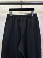 Black shorts with elastic waistband and subtle vertical side stripe details.