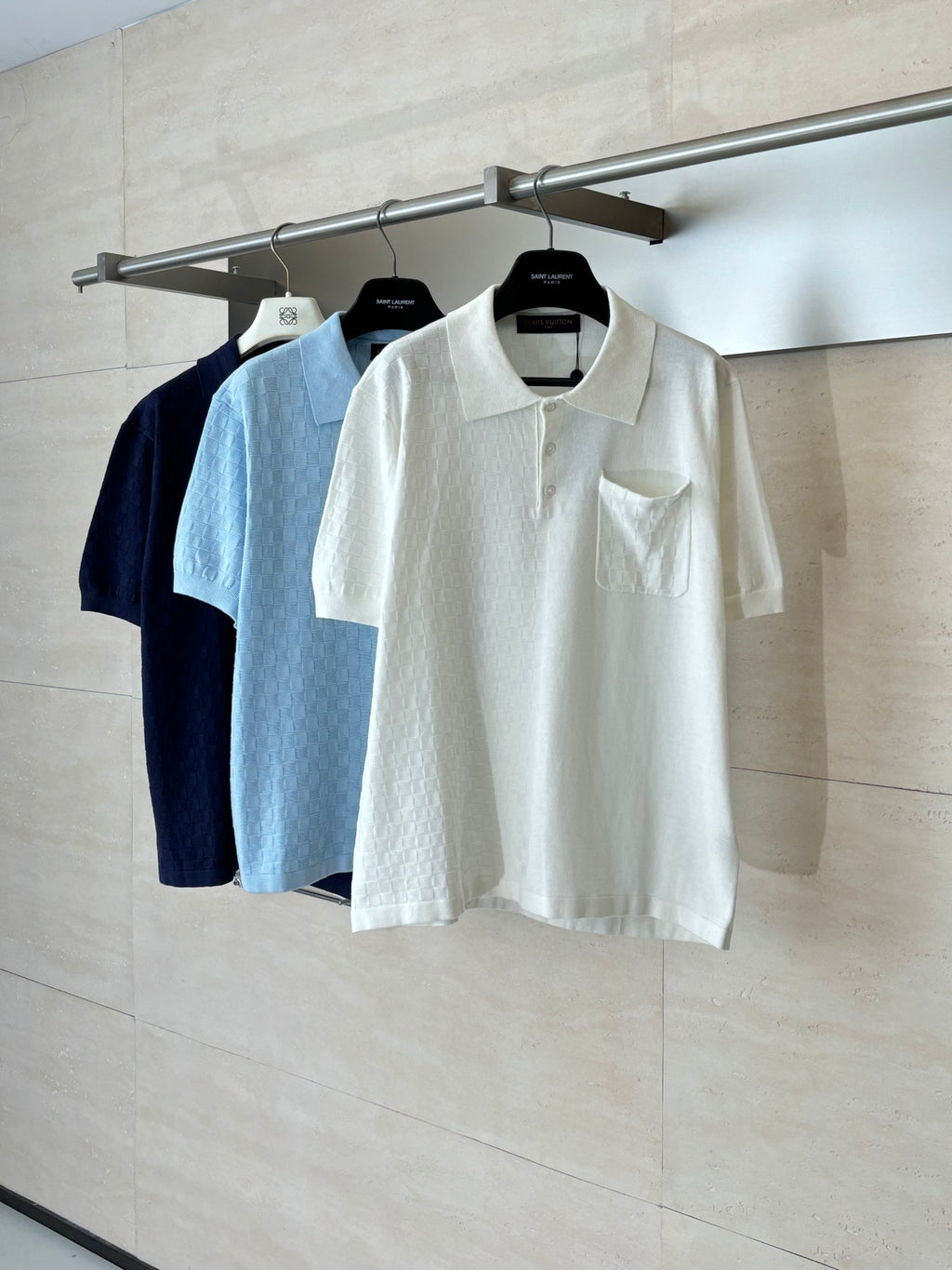 White and dark polo shirts on hangers, short-sleeve collared style