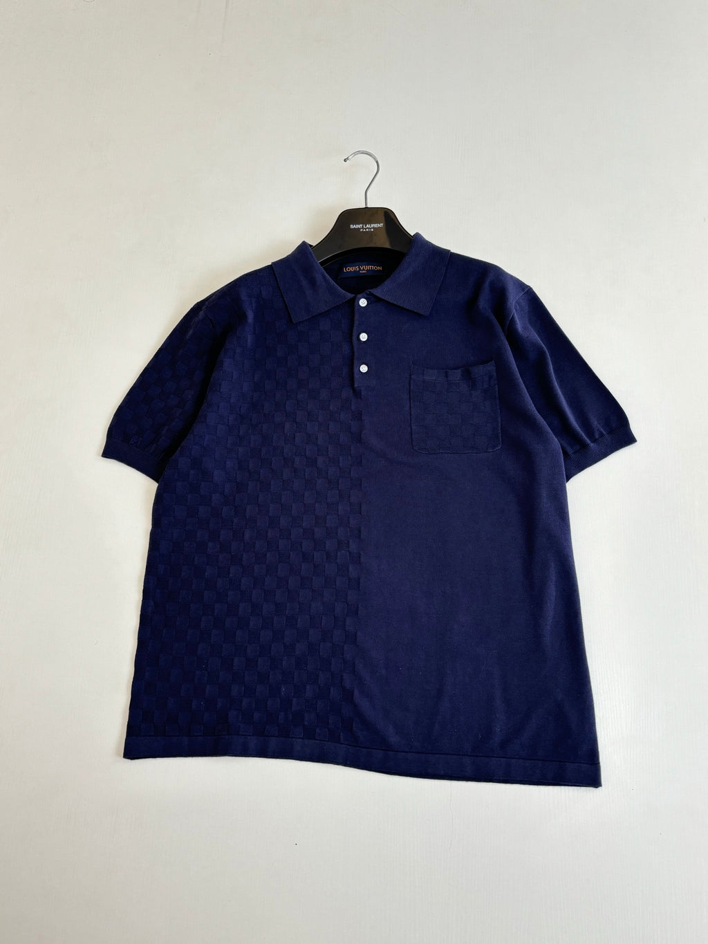 Navy short-sleeve polo shirt with textured check pattern and chest pocket