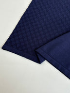 Navy polo shirt sleeve fabric close-up with textured check pattern
