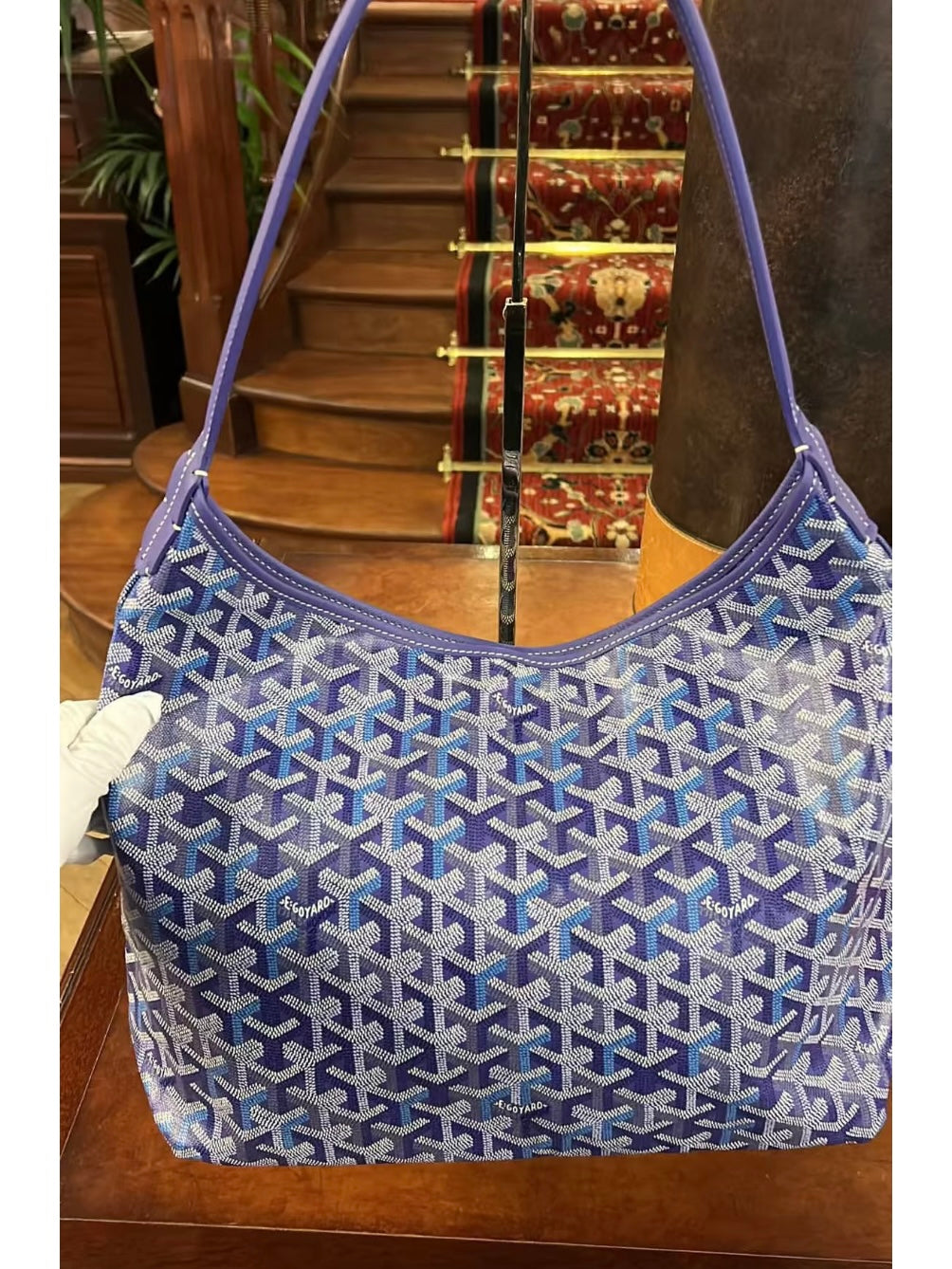 Blue patterned hobo shoulder bag with rounded opening and seam detail.