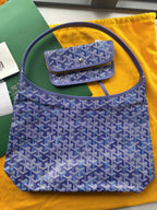 Blue patterned handbag with top handles and front flap pocket.