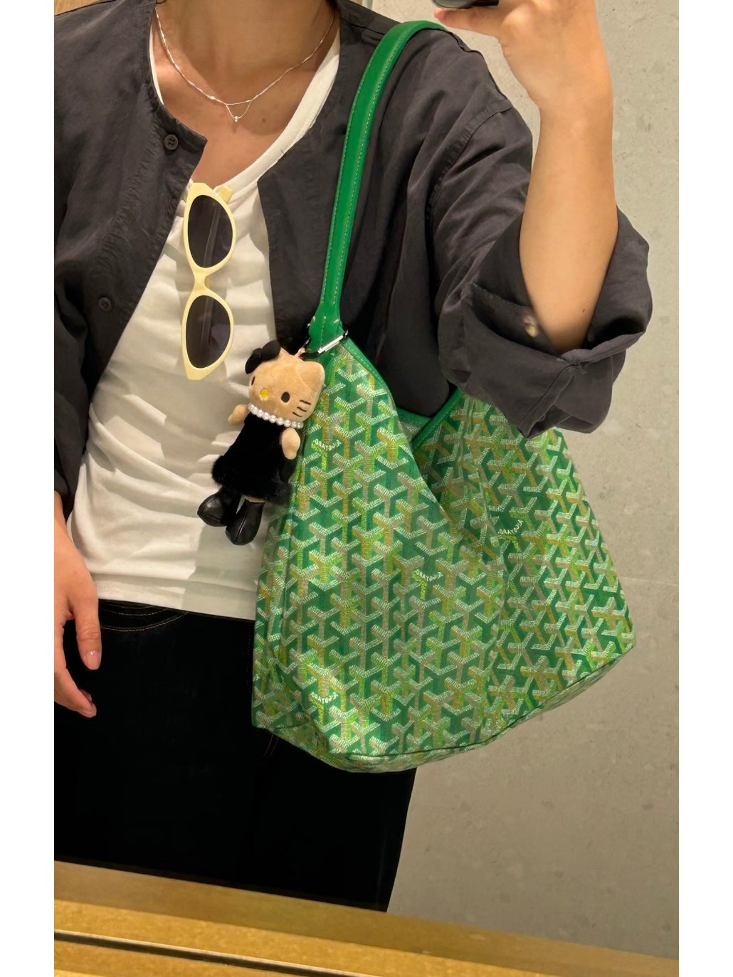 Green lattice-print shoulder bag with top handles and teddy keychain