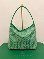 Green lattice-print shoulder bag with curved top handles and gold hardware