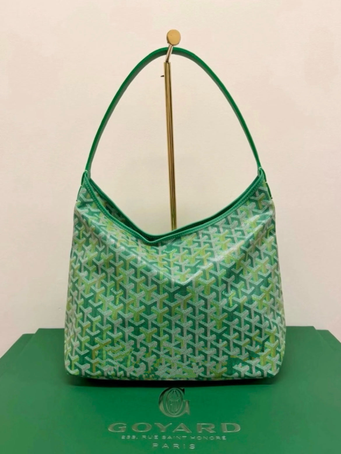 Green lattice-print shoulder bag with curved top handles and gold hardware