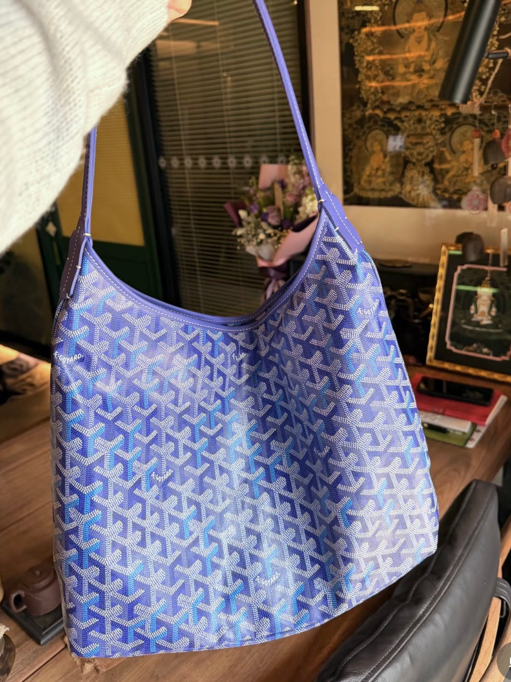 Blue patterned shoulder bag with curved strap and open top.