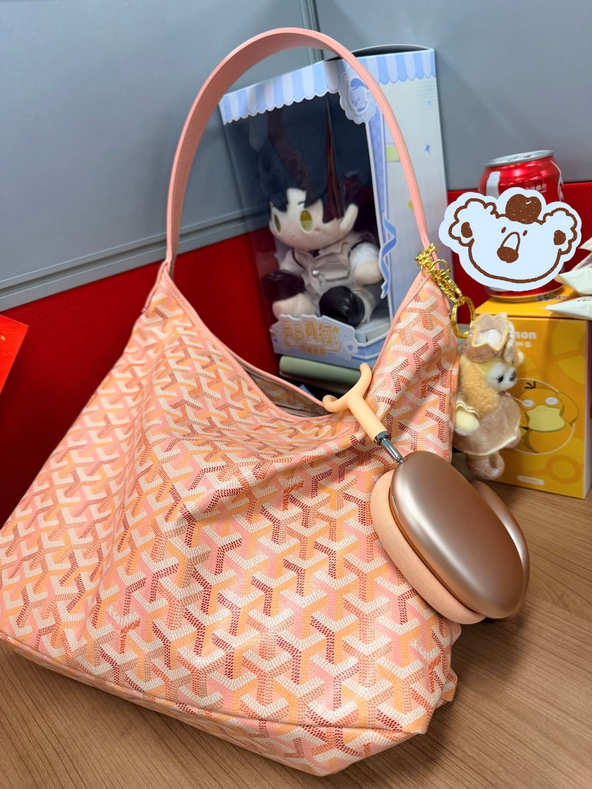 Light pink patterned shoulder bag with wide handles and hanging keychain charm