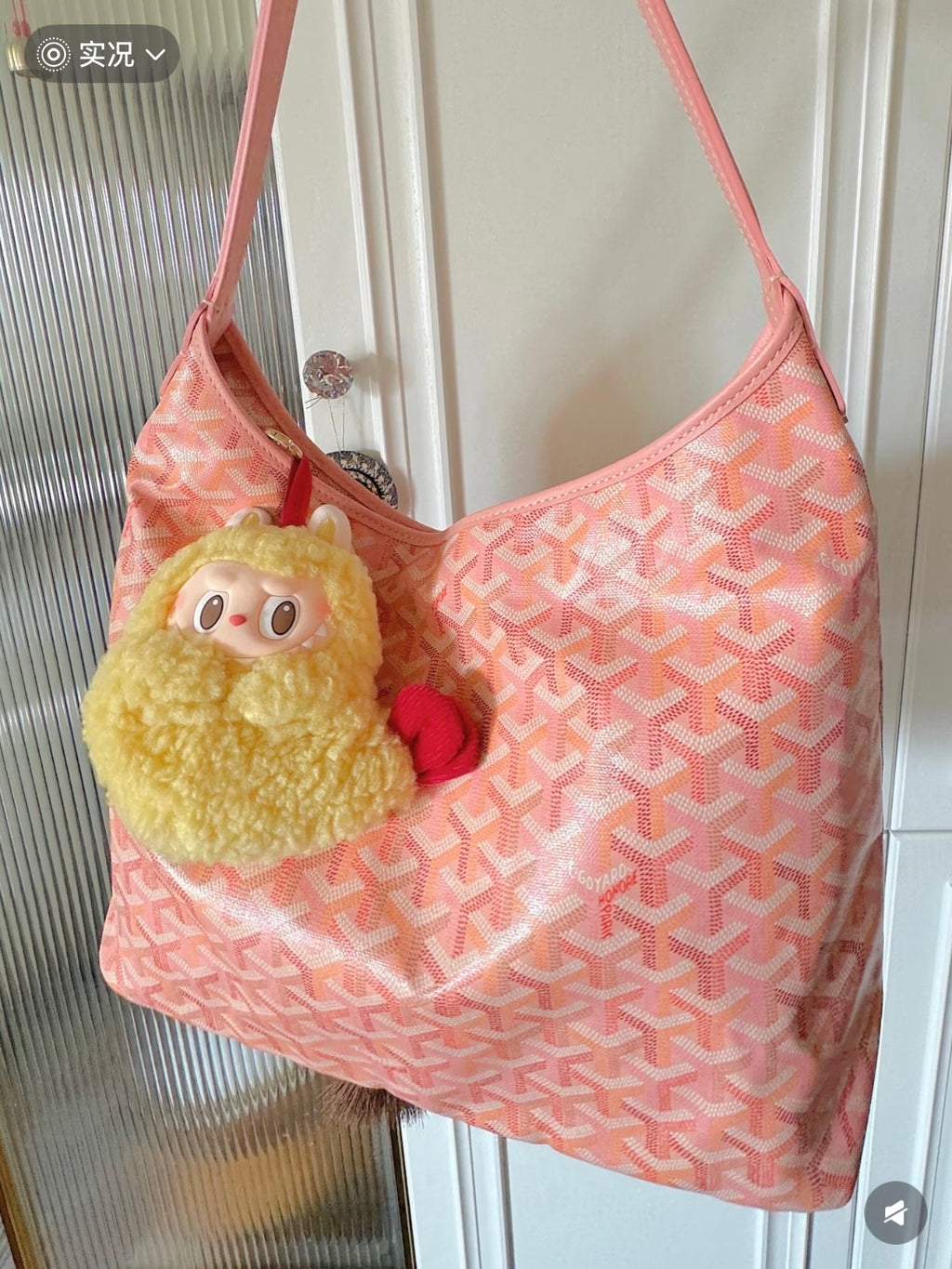Pink patterned shoulder bag with long strap and plush character keychain charm
