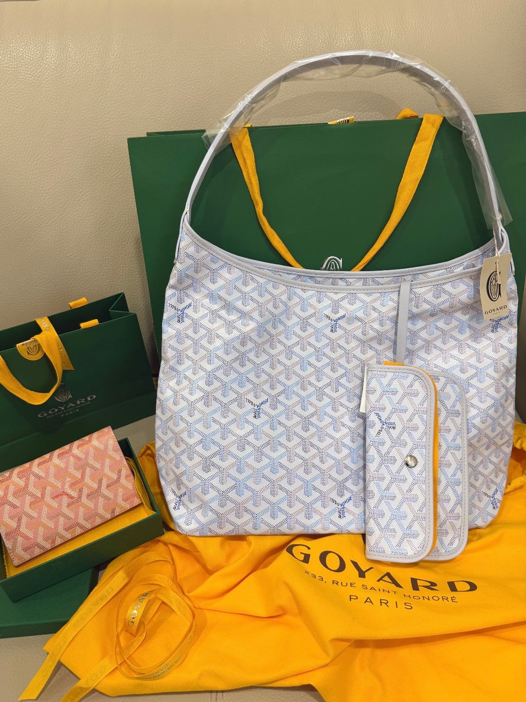 Goyard tote-style handbag in light blue with white pattern, front zip pocket, pouch.