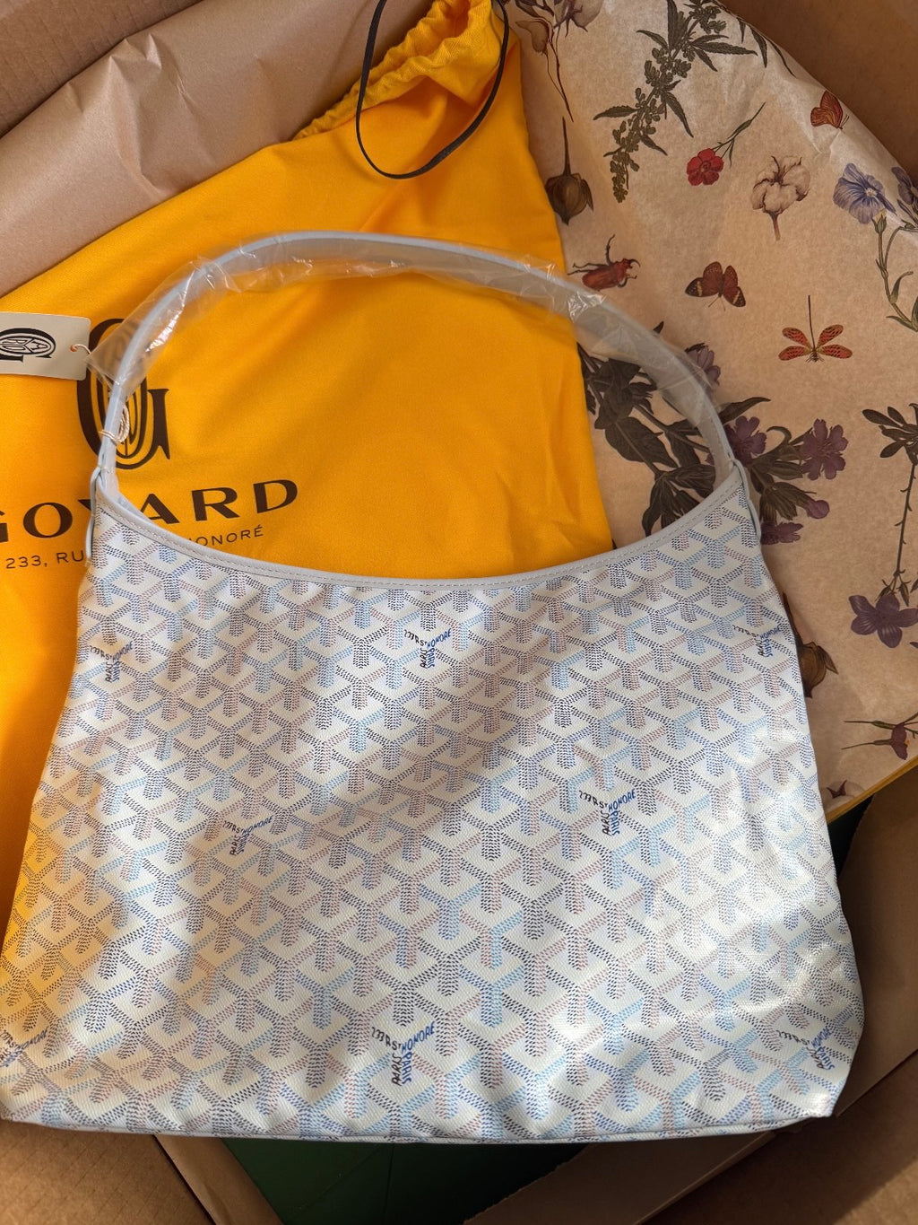 Goyard hobo handbag in light blue with white pattern, open top with dual handles.