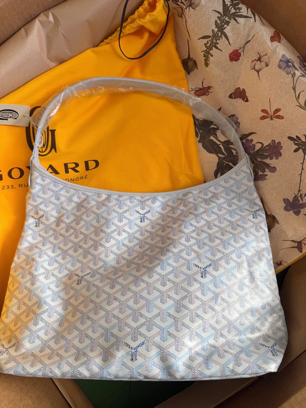 Goyard hobo handbag in light blue with white pattern, open top with dual handles.