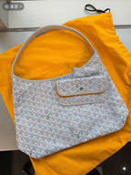 Goyard handbag in light blue with white pattern, dual top handles, flap pocket.
