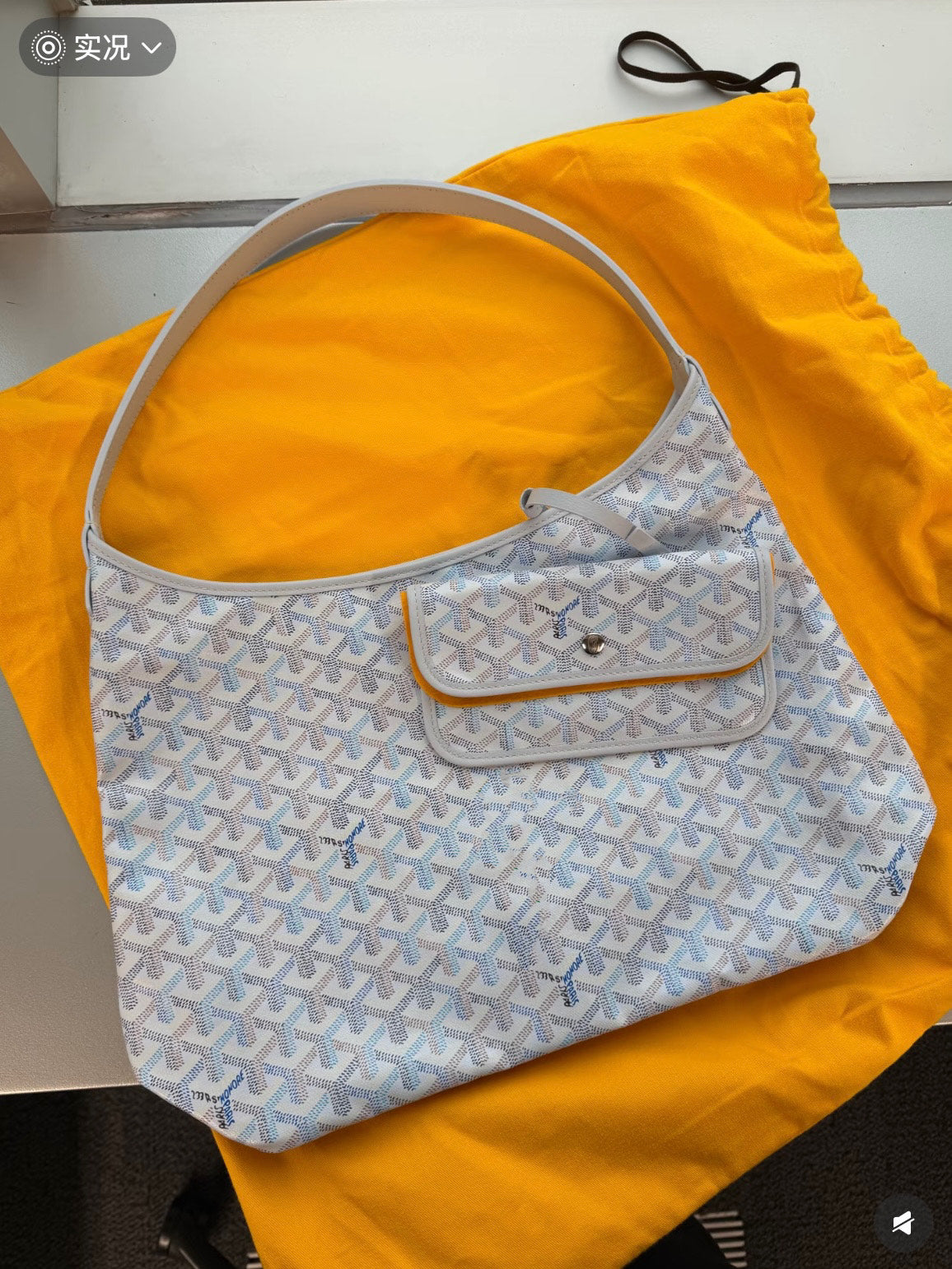 Goyard handbag in light blue with white pattern, dual top handles, flap pocket.