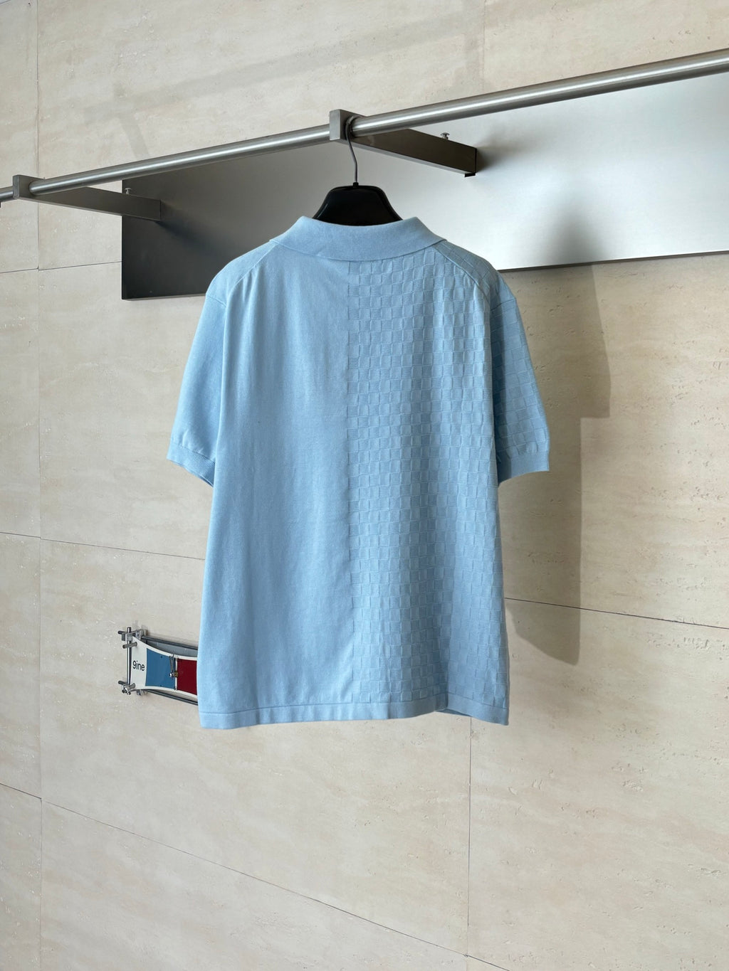 Light blue polo shirt with short sleeves and collar, shown from the back